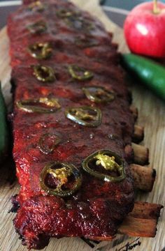 a large piece of meat sitting on top of a cutting board next to some vegetables