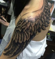 a woman with a large wing tattoo on her arm