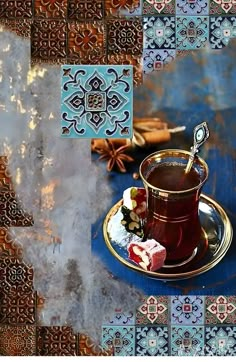 a cup of hot chocolate on a saucer with cinnamon sticks in the background and tile designs