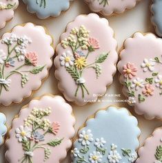 decorated cookies are arranged in rows on a white table top with blue and pink frosting