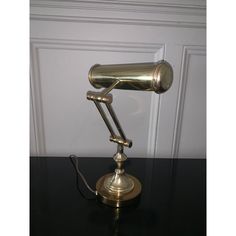 an antique brass desk lamp on a black table