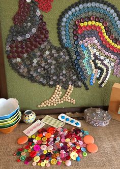 there are many buttons on the table and in front of this wall hanging with a rooster