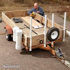 a man is sitting in the back of a trailer with wheels and pipes attached to it