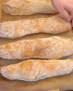 three loaves of bread sitting on top of a piece of wax paper