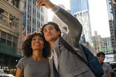 a man and woman taking a selfie in the middle of a busy city street