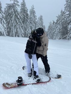 two people on snowboards standing in the snow