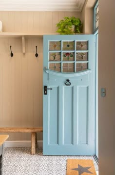 a blue door is open in a small room with a bench and potted plant