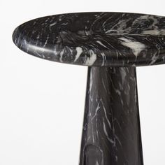 a black and white marbled table top on a metal pedestal with an iron base