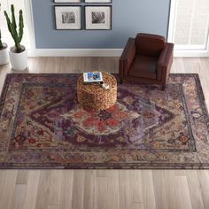 a living room with blue walls and a rug on the floor that has a brown chair in front of it