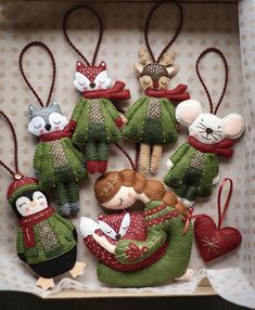 a box filled with christmas ornaments on top of a table next to a wall hanging