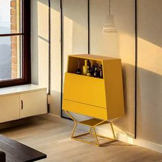 a yellow cabinet sitting next to a window in a living room