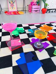 colorful pieces of paper are arranged on a black and white checkered floor