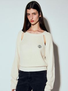 a woman wearing a white sweater with cutouts on the shoulders and an open shoulder