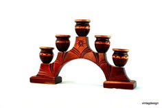 a set of seven wooden candlesticks sitting on top of each other in front of a white background