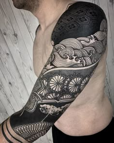 a man with a half sleeve tattoo on his arm