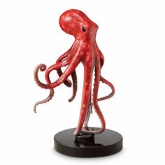 an octopus statue on a black base is shown in front of a white background,