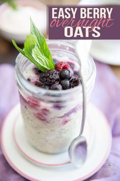 a glass jar filled with berries and yogurt on top of a white plate