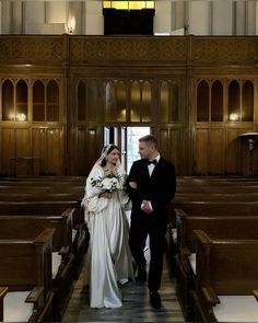 a bride and groom walking down the aisle at their wedding ceremony in an old church