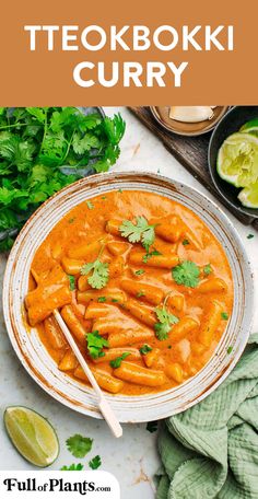 a bowl filled with carrots and cilantro next to some lime wedges