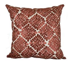 a red and white pillow with an intricate design on the front, sitting on a white background