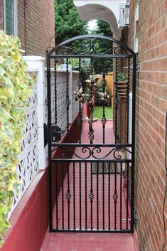 an iron gate on the side of a brick building