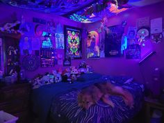 a dog laying on top of a bed in a room with purple lighting and decorations