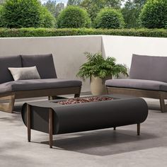 an outdoor seating area with two couches and a fire pit