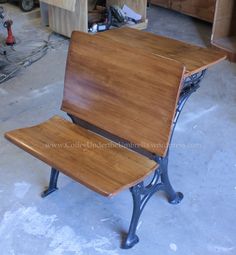 a wooden bench sitting on top of a cement floor next to a workbench