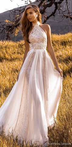 a woman in a white dress walking through tall grass