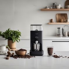 a coffee maker sitting on top of a kitchen counter next to some coffee beans and cups