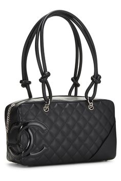 Find CHANEL Cambon Bowler Bag on Editorialist. The Chanel Cambon Bowler Bag is crafted from black calfskin leather and features a quilted design, a top handle with knotted detailing, a silver-tone chain shoulder strap, and a flap closure with a turn lock. The bag also has a spacious interior that can hold all of your essentials. Louis Vuitton Noe Bag, Chanel Cambon, Bowler Bag, Clive Christian, Shopping Chanel, Laura Geller, Cow Boy, Chanel Black, Strap Tops