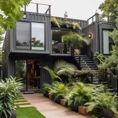 a house that is made out of shipping containers and has plants growing on the outside