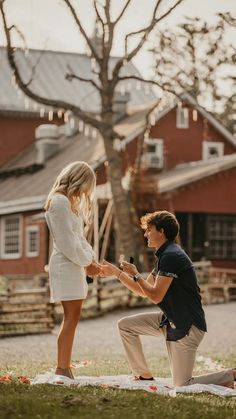 a man kneeling down to give something to a woman