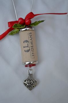 a wine bottle with a heart charm attached to it's side and a red ribbon on top