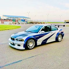 a blue and white car parked on the side of a road next to an airport