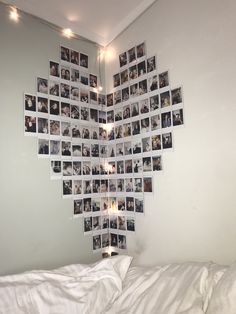 a bed with white sheets and pictures on the wall above it in a room that has been decorated with lights