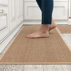 a woman standing on top of a rug in a room