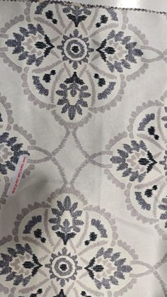 a white and grey rug with black designs on it