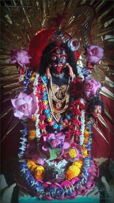 an idol is displayed with flowers and other decorations