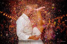 the bride and groom are surrounded by confetti as they stand in front of each other