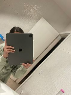 a woman holding an apple laptop in her hands