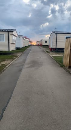 an empty street lined with mobile homes under a cloudy sky