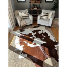 a living room with two chairs and a cowhide rug