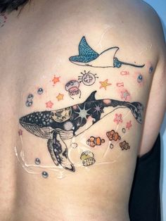 a woman with a tattoo on her stomach has an image of a whale and fish