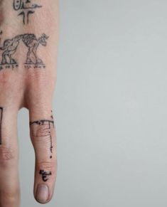 a person's hand with some tattoos on it