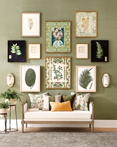 a living room filled with lots of framed pictures on the wall above a white couch