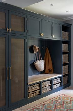 an entryway with blue cabinets and baskets on the wall, including a coat rack