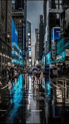 people are crossing the street in the city on a rainy day