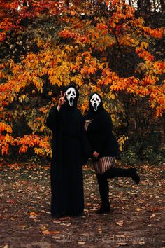 two people dressed up in black and white masks