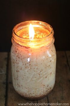 a lit candle sitting on top of a wooden table